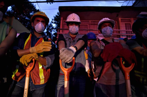 Volunteer rescuers stand by for their turn to arrive to begin taking part in the cleanup of rubble from collapsed buildings in search of survivors, in Mexico City, on September 20, 2017 one day after a powerful 7.1-magnitude quake devastated part of the country.At least 216 people were killed when a powerful 7.1-magnitude earthquake struck Mexico on Tuesday, including 21 children crushed beneath an elementary school that was reduced to rubble. / AFP PHOTO / Alfredo ESTRELLA