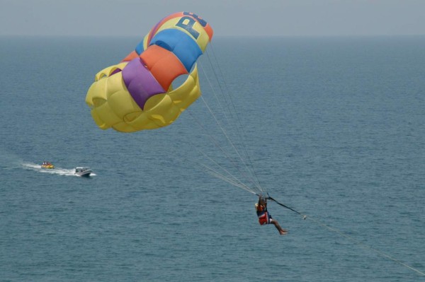 Algunos prefieren ver las playas desde las alturas y son halados desde una lancha mientras ellos vuelan con un paracaídas.