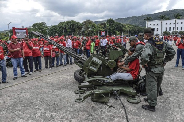 Members of the national army show locals how to handle an antiaircraft battery during military drills in Caracas on August 26, 2017.Venezuela kicks off two days of military drills in response to US President Donald Trump's threat of military action and newly announced sanctions on the crisis-stricken nation. / AFP PHOTO / JUAN BARRETO