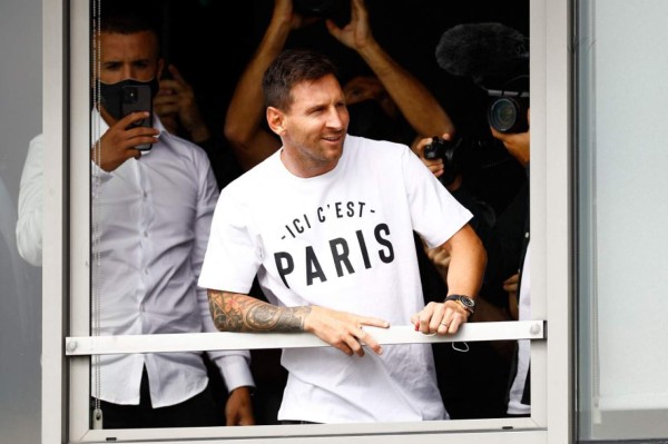 Argentinian football player Lionel Messi leans in a window as he salutes supporters after he landed on August 10, 2021 at Le Bourget airport, north of Paris, to become Paris Saint-Germain's new player following his departure from Barcelona, the club he has represented for the entirety of his 17-year professional career so far. - Asked by reporters at Barcelona's El Prat airport if the Argentine star would later on sign with the French club, Jorge Messi, the father and player's agent, said: 'Yes'. (Photo by Sameer Al-DOUMY / AFP)