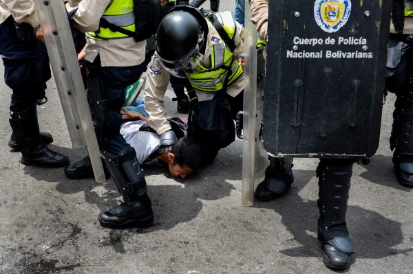 A man is arrested during a protest against new emergency powers decreed this week by President Nicolas Maduro in Caracas on May 18, 2016. Public outrage was expected to spill onto the streets of Venezuela Wednesday, with planned nationwide protests marking a new low point in Maduro's unpopular rule. / AFP PHOTO / FEDERICO PARRA