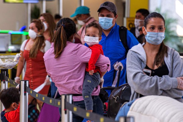 USA1145. FORT LAUDERDALE (ESTADOS UNIDOS), 18/04/2020.- Un grupo de ciudadanos y residentes de Honduras varados en Estados Unidos por el coronavirus esperan en fila para subir a un avión este sábado en el Aeropuerto Internacional de Fort Lauderdale, a 40 kilómetros al norte de Miami, Florida (EEUU). Un vuelo especial de la compañía Spirit se llevó este sábado de regreso a su país a 150 hondureños a los que el cierre de fronteras por el COVID-19 sorprendió estando de visita en EE.UU. y quedaron varados, una situación en la que todavía están muchos otros que esperan una nueva oportunidad para viajar. EFE/Giorgio Viera