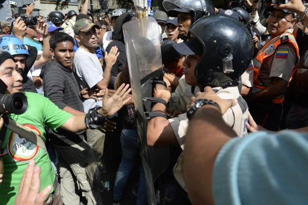 Pro government supporters struggle with police outside the congress during the new parliamentaries' swearing in ceremony in Caracas, on January 5, 2016 in support of their newly elected deputies in the day of their installation. enezuela's opposition takes control of the legislature Tuesday for the first time in 17 years, but President Nicolas Maduro bid to outmaneuver them by seizing control of the central bank. AFP PHOTO/FEDERICO PARRA