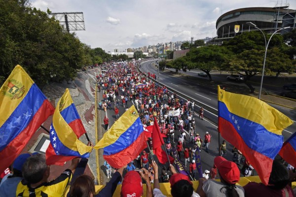 Supporters of Venezuelan President Nicolas Maduro take part in a pro-government May Day rally in Caracas on May 1, 2019. - Pro- and anti-government rallies are taking place in Venezuela, a day after violent clashes erupted in the capital following opposition leader Juan Guido's call on the military to rise up against Maduro, who claimed the insurrection had failed. (Photo by Juan BARRETO / AFP)