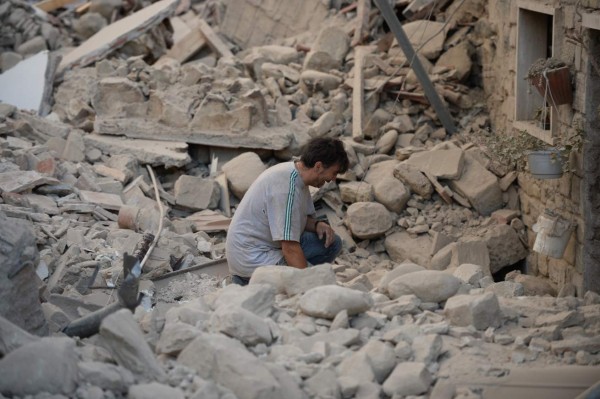A man reacts to his damaged home after a strong earthquake hit Amatrice on August 24, 2016.Central Italy was struck by a powerful, 6.2-magnitude earthquake in the early hours, which has killed at least three people and devastated dozens of mountain villages. Numerous buildings had collapsed in communities close to the epicenter of the quake near the town of Norcia in the region of Umbria, witnesses told Italian media, with an increase in the death toll highly likely. / AFP PHOTO / FILIPPO MONTEFORTE