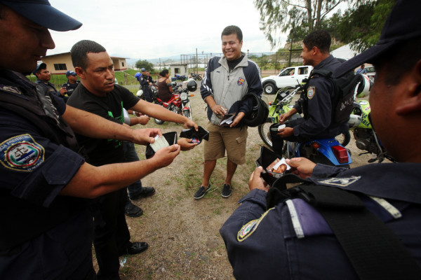 Policías hondureños exigen salarios mostrando carteras vacías