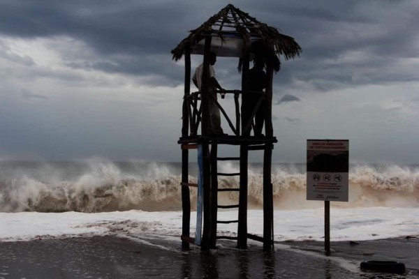 Dos hombres observan el fuerte oleaje hoy, viernes 5 de septiembre de 2014, debido a la influencia del huracán Norbert, en una playa en el puerto de Mazatlán, noroeste de México. Las autoridades mexicanas declararon hoy en alerta roja (peligro máximo) la zona meridional del estado de Baja California Sur por la cercanía del huracán Norbert, que genera lluvias de intensas a fuertes en el noroeste del país. EFE