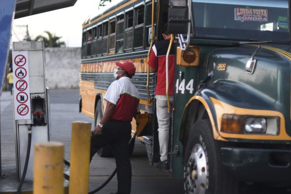 A worker of a gas pump station wears a face mask, as a precautionary measure against the spread of the new coronavirus, COVID-19, in Guatemala City, on March 16, 2020. - Guatemala's President Alejandro Giammattei announced Monday the closure of borders and the suspension of international flights to confront the new coronavirus, after the death of a contagious and the increase of cases. (Photo by Johan ORDONEZ / AFP)