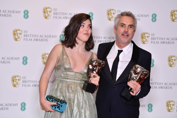 Mexican director Alfonso Cuaron (R) and his daughter Tessa pose with the awards for a Director and for Best Film for 'Roma' at the BAFTA British Academy Film Awards at the Royal Albert Hall in London on February 10, 2019 (Photo by Ben STANSALL / AFP)