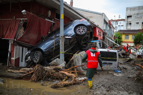 A rescue worker walks through the mud and debris after flash floods destroyed parts of the town of Bozkurt in the district of Kastamonu, in the Black Sea region of Turkey on August 14, 2021. - Turkey battled disaster on two fronts on August 14, 2021, with eight people dying when a fire-fighting aircraft crashed and rescuers racing to find survivors of flash floods in the north that have killed at least 55. (Photo by STR / AFP)