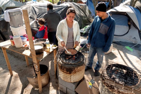 Improvised wood-burning stoves dot the encampment that has risen on the Mexican bank of the Rio Grande, where hundreds of tarps have been provided by the Mexican government as part of its effort to take care of migrants turned back by the United States under the 'Remain in Mexico' initiative. EPA-EFE/CRISTOBAL HERRERA EPA-EFE/CRISTOBAL HERRERA