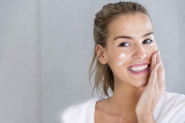 Beauty portrait of a woman using moisturizing cream