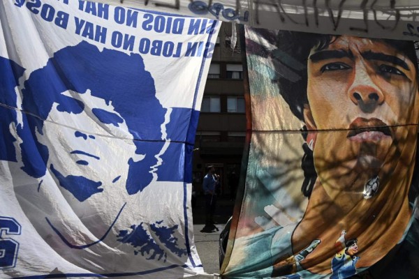 Flags depicting Argentine former football star and coach of Gimnasia y Esgrima La Plata Diego Maradona, hang outside the Ipensa clinic where Maradona has been admitted, in La Plata, Buenos Aires province, on November 3, 2020. - Argentine football great Diego Maradona was admitted to hospital Monday for medical checks, his personal doctor announced. (Photo by JUAN MABROMATA / AFP)