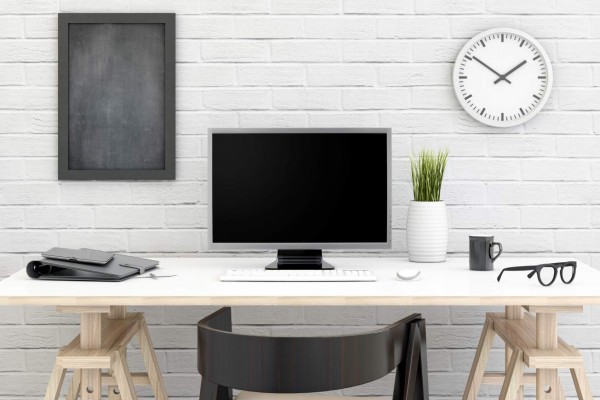 Scene shows business work setup. modern looking in front of a white brick wall with blackboard, clock...