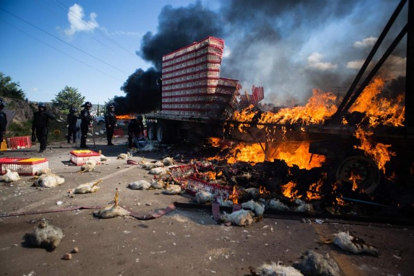 Members of Mexican Federal Police clash with teachers holding a protest against an education reform and the arrest of two of their leaders, in Oaxaca State, on June 19, 2016. At least three people were killed and dozens injured when police clashed with thousands of teachers blocking roads in a protest in southern Mexico on Sunday, leaving some officers with bullet wounds. / AFP PHOTO / STR