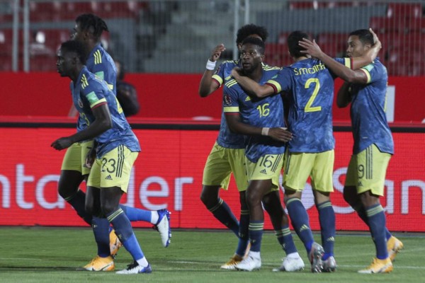 Colombia's players celebrate after scoring against Chile during their 2022 FIFA World Cup South American qualifier football match at the National Stadium in Santiago, on October 13, 2020, amid the COVID-19 novel coronavirus pandemic. (Photo by Esteban Felix / POOL / AFP)