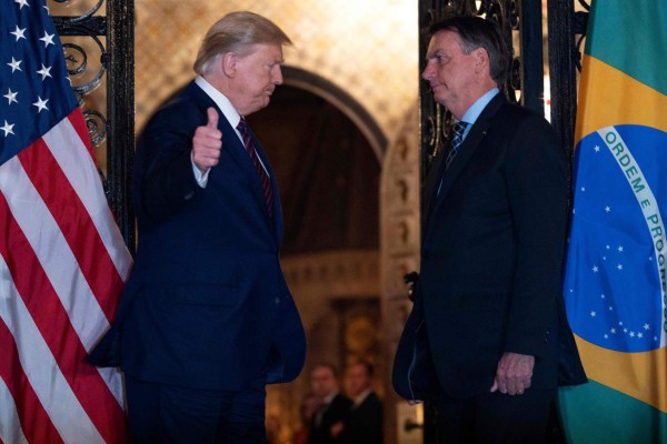 (FILES) In this file photo US President Donald Trump (L) speaks with Brazilian President Jair Bolsonaro during a dinner at Mar-a-Lago in Palm Beach, Florida, on March 7, 2020. - Brazilian President Jair Bolsonaro said on March 12 he will know 'in the next few hours' if he has contracted the new coronavirus after a top aide tested positive for the disease following a trip on which both met with US President Donald Trump. (Photo by JIM WATSON / AFP)