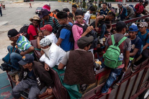 Migrants -mostly Hondurans- heading in a caravan to the US, are seen onboard a truck as they catch a ride in Isla, Veracruz state, on their way to Puebla, Mexico, on November 3, 2018. - President Donald Trump on Thursday warned that soldiers deployed to the Mexican border could shoot Central American migrants who throw stones at them while attempting to cross illegally. (Photo by Guillermo Arias / AFP)
