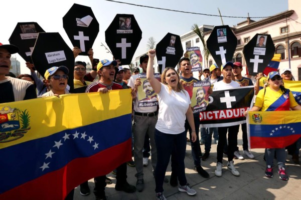 Members of the Venezuelan community in Peru protest against the presidential election in their country, in the surroundings of the Venezuelan embassy in Lima, on May 20, 2018.Despite the fact that almost 300,000 Venezuelans have migrated to Peru, only some 600 of them are able to vote as the embassy's electoral register has not been updated since 2012 forbidding those who arrived after this date to vote. / AFP PHOTO / Luka GONZALES
