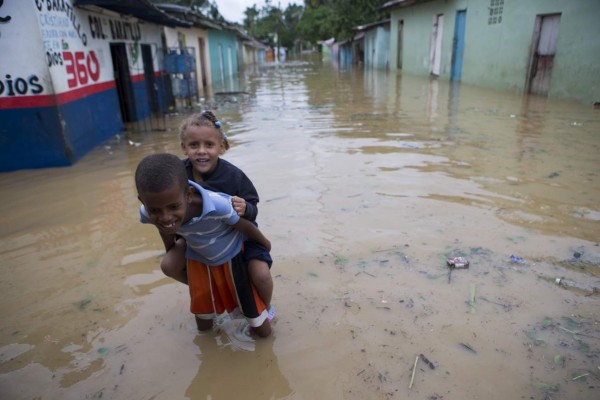STO56. HIGÜEY (REPÚBLICA DOMINICANA), 21/09/2017.-Niños del barrio La Florida caminan por una calle inundada hoy, jueves 21 de septiembre de 2017, tras el paso del huracán María, en Higüey (República Dominicana). El huracán María dejó sin electricidad a miles de personas en la República Dominicana, especialmente en el este y el norte, informaron hoy fuentes del sector. EFE/Orlando Barría