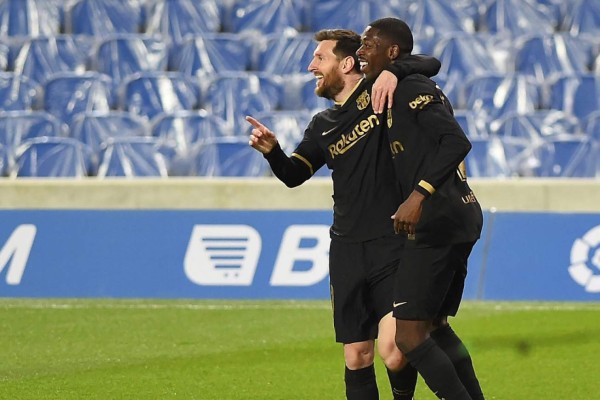 Barcelona's Argentinian forward Lionel Messi (back) celebrates with Barcelona's French midfielder Ousmane Dembele after scoring a goal during the Spanish League football match between Real Sociedad and Barcelona at the Anoeta stadium in San Sebastian on March 21, 2021. (Photo by ANDER GILLENEA / AFP)