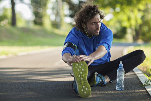 Close up of a sporty man stretching after running