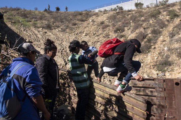 Caravana migrante: Familia hondureña arriesga su vida al saltar el muro con un bebé en brazos