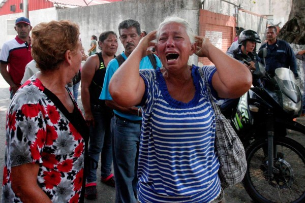 A relative of a prisoner cries in front of a police station in Valencia on March 28, 2017, after a fire engulfed police holding cells that resulted in the deaths of 68 people. A total of 68 people died on March 28 during an attempted jailbreak in Venezuela after a fire engulfed police holding cells in one of the worst tragedies in years in a notoriously violent and overcrowded prison system. / AFP PHOTO / Katherine ORTIZ