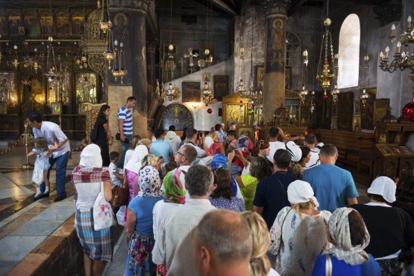 Bethlehem, West Bank, Palestinian Territories - July 23, 2013: Visitors line up inside the historic Church of the Nativity to descend into the grotto, where tradition holds that Jesus was born, in the West Bank town of Bethlehem.