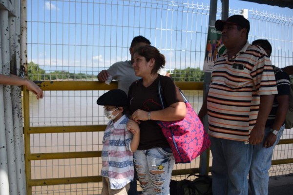 Honduran migrants María Argentina Paz (C) and her son Mery Sair, 6, -who is affected by a terminal cancer- wait to cross the international border bridge from Ciudad Tecun Uman in Guatemala to Ciudad Hidalgo in Mexico, on November 1, 2018. - The Honduran migrants Rodrigo Villanueva (out of frame) and Maria Argentina Paz is marching to the United States, in a desperate search for treatment for his six-year-old boy. (Photo by Johan ORDONEZ / AFP) / The erroneous mention appearing in the metadata of this photo by Johan ORDONEZ has been modified in AFP systems in the following manner: [Honduran migrant Maria Argentina Paz and her son Mery Sair] instead of [Salvadorean migrants]. Please immediately remove the erroneous mention[s] from all your online services and delete it (them) from your servers. If you have been authorized by AFP to distribute it (them) to third parties, please ensure that the same actions are carried out by them. Failure to promptly comply with these instructions will entail liability on your part for any continued or post notification usage. Therefore we thank you very much for all your attention and prompt action. We are sorry for the inconvenience this notification may cause and remain at your disposal for any further information you may require.