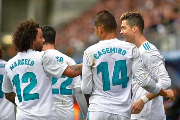 Real Madrid's Portuguese forward Cristiano Ronaldo (R) celebrates with teammates after scoring a goal during the Spanish league football match between Eibar and Real Madrid at the Ipurua stadium in Eibar on March 10, 2018. / AFP PHOTO / ANDER GILLENEA
