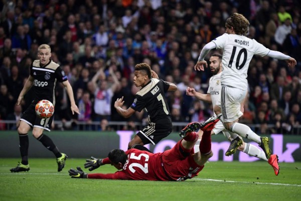 Ajax's Brazilian forward David Neres (C) scores against Real Madrid's Belgian goalkeeper Thibaut Courtois (L) during the UEFA Champions League round of 16 second leg football match between Real Madrid CF and Ajax at the Santiago Bernabeu stadium in Madrid on March 5, 2019. (Photo by JAVIER SORIANO / AFP)