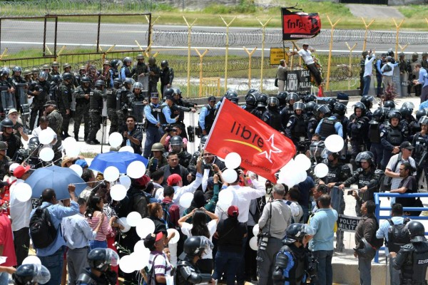 Supporters of the Libertad y Refundacion (LIBRE) party demonstrte near the site where fellow activist Isi Obed Murillo was killed outside Toncontin International Airport in Tegucigalpa, on June 28, 2019, during a protest to commemorate the 10th anniversary of former President (2006-2009) Manuel Zelaya's ouster. - Isis Obed Murillo was killed by a sniper on July 5, 2009 to the south of the airport, when the ousted president attempted to return to the country on a Venezuelan airplane. (Photo by ORLANDO SIERRA / AFP)