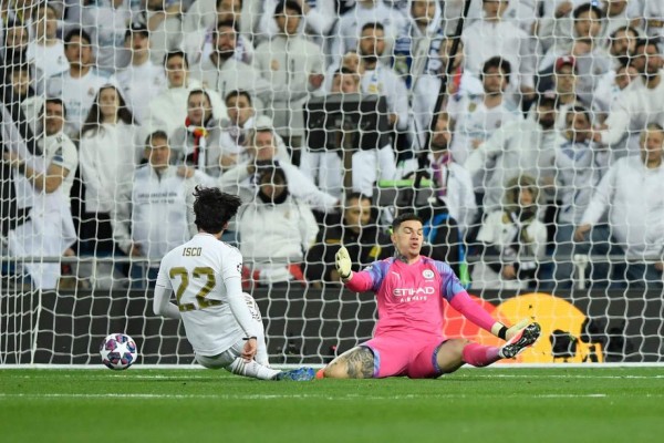 Real Madrid's Spanish midfielder Isco (L) scores a goal past Manchester City's Brazilian goalkeeper Ederson during the UEFA Champions League round of 16 first-leg football match between Real Madrid CF and Manchester City at the Santiago Bernabeu stadium in Madrid on February 26, 2020. (Photo by OSCAR DEL POZO / AFP)