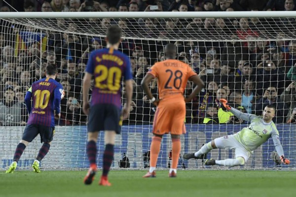 Barcelona's Argentinian forward Lionel Messi (L) shoots a penalty kick to score the opening goal during the UEFA Champions League round of 16, second leg football match between FC Barcelona and Olympique Lyonnais at the Camp Nou stadium in Barcelona on March 13, 2019. (Photo by LLUIS GENE / AFP)