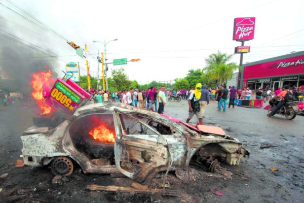 Riot police clash with students and activists demanding the resignation of Honduran President Juan Orlando Hernandez for his alleged links with drug trafficking, in Tegucigalpa on August 7, 2019. (Photo by ORLANDO SIERRA / AFP)
