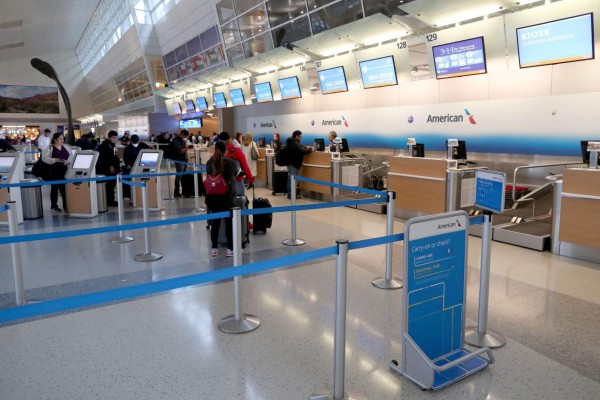 DALLAS, TEXAS - MARCH 13: A passenger checks in for an American Airlines in Terminal D at Dallas/Fort Worth International Airport (DFW) on March 13, 2020 in Dallas, Texas. American Airlines announced that it is cutting a third of its international flights amid a major slowdown due to the Coronavirus (COVID-19) outbreak. Tom Pennington/Getty Images/AFP== FOR NEWSPAPERS, INTERNET, TELCOS & TELEVISION USE ONLY ==