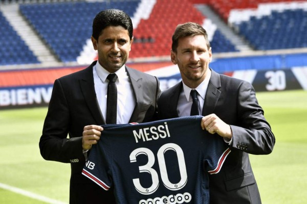 Paris Saint-Germain's Qatari President Nasser Al-Khelaifi (L) poses along side Argentinian football player Lionel Messi as he holds-up his number 30 shirt while standing on the pitch during a press conference at the French football club Paris Saint-Germain's (PSG) Parc des Princes stadium in Paris on August 11, 2021. - The 34-year-old superstar signed a two-year deal with PSG on August 10, 2021, with the option of an additional year, he will wear the number 30 in Paris, the number he had when he began his professional career at Spain's Barca football club. (Photo by STEPHANE DE SAKUTIN / AFP)