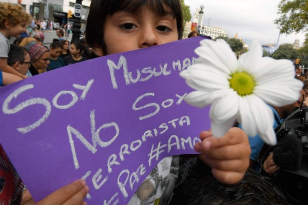 Omar, 4 year-old, holds a message reading 'I a Muslim, not a terrorist' as Muslim residents of Barcelona demonstrate on the Las Ramblas boulevard in Barcelona, to protest against terrorism and in tribute to the victims of the Barcelona attack on August 19, 2017, two days after a van ploughed into the crowd, killing 13 persons and injuring over 100.Drivers have ploughed on August 17, 2017 into pedestrians in two quick-succession, separate attacks in Barcelona and another popular Spanish seaside city, leaving 14 people dead and injuring more than 100 others. / AFP PHOTO / LLUIS GENE