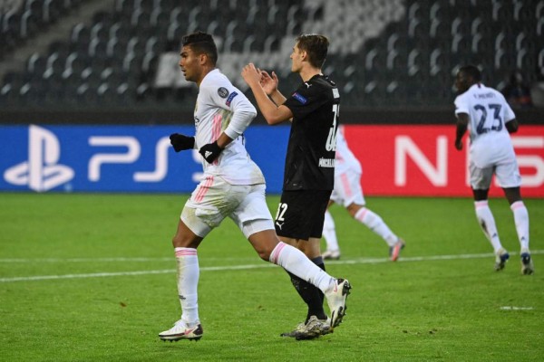 Real Madrid's Brazilian midfielder Casemiro (L) celebrates scoring the 2-2 goal during the UEFA Champions League group B football match Borussia Moenchengladbach v Real Madrid in Moenchengladbach, western Germany on October 27, 2020. (Photo by Ina Fassbender / AFP)