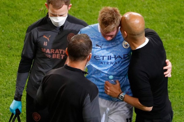 Manchester City's Spanish coach Josep Guardiola (R) speaks to Manchester City's Belgian midfielder Kevin De Bruyne after his injury during the UEFA Champions League final football match between Manchester City and Chelsea at the Dragao stadium in Porto on May 29, 2021. (Photo by SUSANA VERA / POOL / AFP)