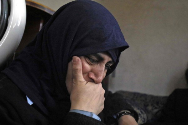 Con un rosario en una mano y dos loros en la otra, una cristiana huye de Raqa