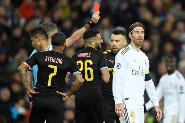 Real Madrid's Spanish defender Sergio Ramos (R) receives a red card from Italian referee Daniele Orsato during the UEFA Champions League round of 16 first-leg football match between Real Madrid CF and Manchester City at the Santiago Bernabeu stadium in Madrid on February 26, 2020. (Photo by OSCAR DEL POZO / AFP)