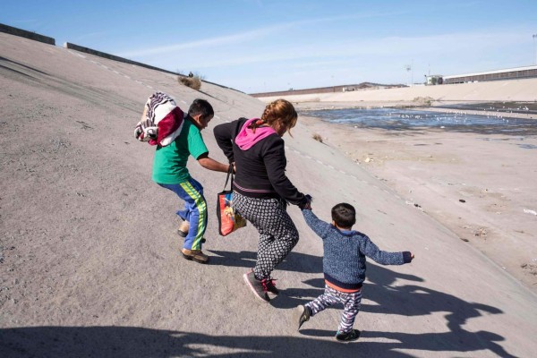 A group of Central American migrants -mostly from Honduras- run along the dry riverbed of the Tijuana River in an attempt to get to El Chaparral port of entry, in Tijuana, Baja California State, Mexico, near US-Mexico border on November 25, 2018. - Hundreds of migrants attempted to storm a border fence separating Mexico from the US on Sunday amid mounting fears they will be kept in Mexico while their applications for a asylum are processed. An AFP photographer said the migrants broke away from a peaceful march at a border bridge and tried to climb over a metal border barrier in the attempt to enter the United States. (Photo by GUILLERMO ARIAS / AFP)