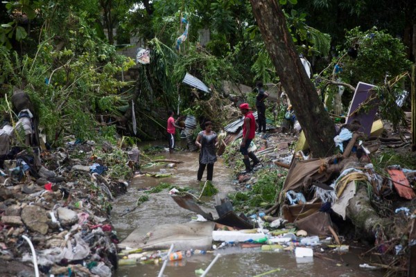 TOPSHOT - Locals try to rescue their belonging after the overflow of the Magua river caused by heavy rains caused during Isaias storm in the city of Hato Mayor, northwest of Santo Domingo, Dominican Republic, on July 31, 2020. (Photo by Erika SANTELICES / AFP)