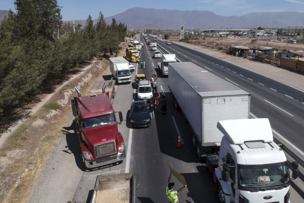 People demonstrate with their cars, trucks, and taxis on the Route 5 North at the 'No more TAG' protest in Santiago, after a week of street violence which erupted against a now suspended metro fare hike but spiralled into general discontent in Santiago, on October 25, 2019. - The highways of the Chilean Metropolitan region became Friday the centre of the protests that a week ago affect the country, with rows of trucks and private cars demonstrating at the routes in rejection of the high prices of electronic toll collection (tag). (Photo by Pablo VERA / Pablo Vera/AFP / AFP)