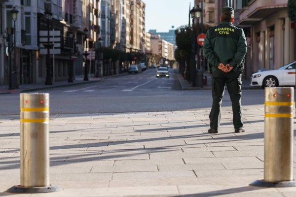 A Guardia Civil member stands guard in the centre of Burgos in northern Spain on March 15, 2020. - France and Spain are the latest European nations to severely curtail people's movements as countries across the Americas and Asia impose travel restrictions in a widening crisis over coronavirus, as the number of infections around the world passed 150,000, with nearly 6,000 deaths. (Photo by CESAR MANSO / AFP)