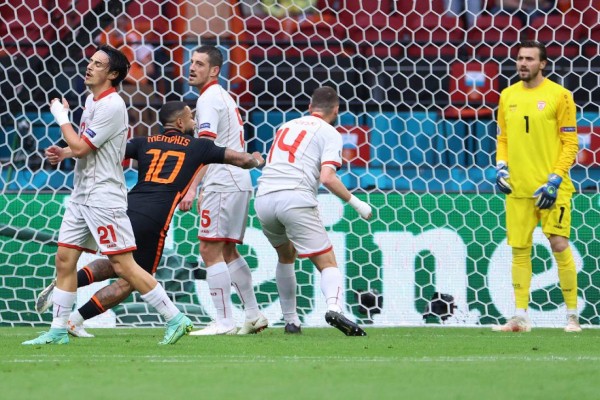 Netherlands' forward Memphis Depay (2L) scores his team's opening goal during the UEFA EURO 2020 Group C football match between North Macedonia and the Netherlands at Johan Cruyff Arena in Amsterdam on June 21, 2021. (Photo by KENZO TRIBOUILLARD / POOL / AFP)