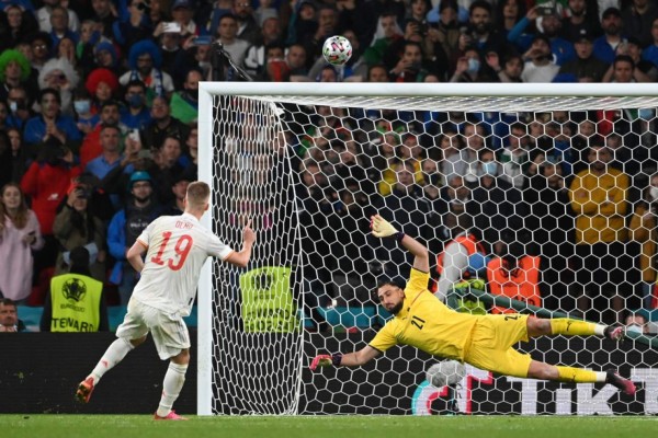 Spain's midfielder Daniel Olmo (L) shoots the penalty over the goal of Italy's goalkeeper Gianluigi Donnarumma during the UEFA EURO 2020 semi-final football match between Italy and Spain at Wembley Stadium in London on July 6, 2021. (Photo by Andy Rain / POOL / AFP)