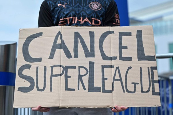 A supporter wearing a Manchester City shirt holds up a placard critical of the idea of a New European Super League, outside English Premier League club Chelsea's Stamford Bridge stadium in London on April 20, 2021, ahead of their game against Brighton. - The 14 Premier League clubs not involved in the proposed European Super League 'unanimously and vigorously rejected' the plans at an emergency meeting on Tuesday. Liverpool, Arsenal, Chelsea, Manchester City, Manchester United and Tottenham Hotspur are the English clubs involved. (Photo by JUSTIN TALLIS / AFP)